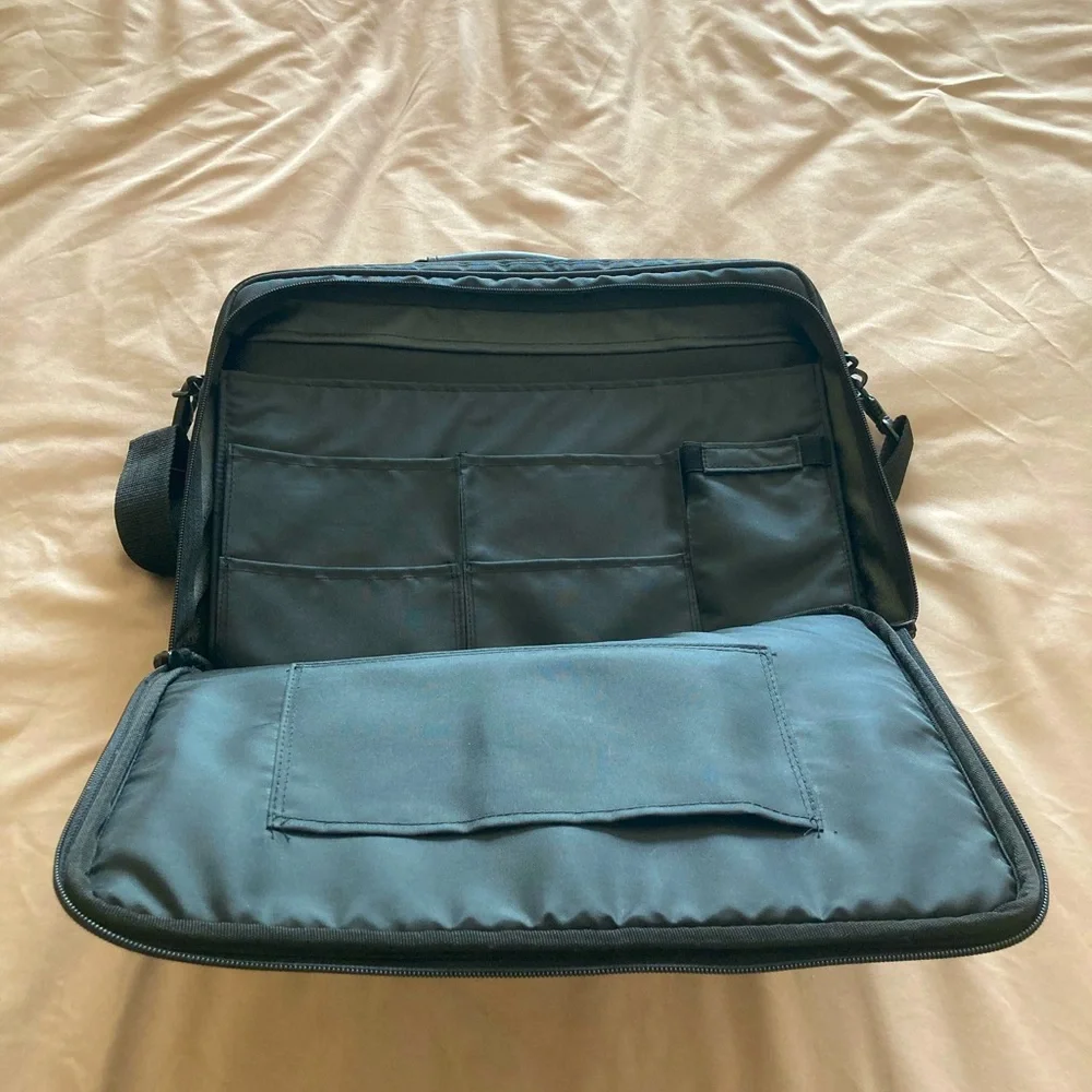 Gently used laptop bag in black nylon with several compartments.